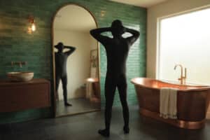 Im Catsuit im Badezimmer vor dem Spiegel