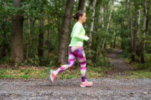 Frau in Leggings läuft im Wald