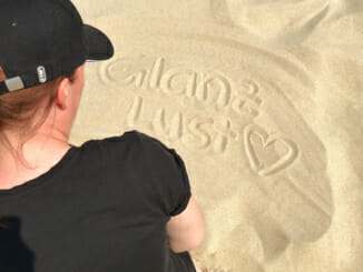 Katy Glossy Glanzlust Schrift im Sand geschrieben